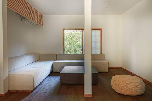 ein Wohnzimmer mit einem Sofa und einem Tisch in der Unterkunft じぇーむすのおうち in Yawatano