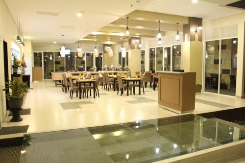 a restaurant with a dining room with tables and chairs at LAMORA Sagan Yogyakarta - formerly H Boutique Yogyakarta in Yogyakarta