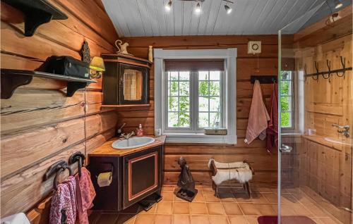 uma casa de banho com paredes de madeira, um lavatório e uma janela em 3 Bedroom Pet Friendly Home In Svingvoll em Svingvoll