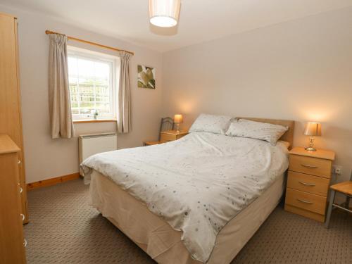 a bedroom with a large bed and a window at Ty Hen in Pwllheli