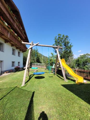 plac zabaw ze zjeżdżalnią i huśtawkami w obiekcie Gästehaus Bergwald w mieście Virgen