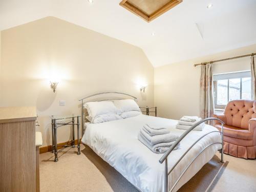 a bedroom with a bed and a chair at The Hayloft - Uk44519 in Tetney