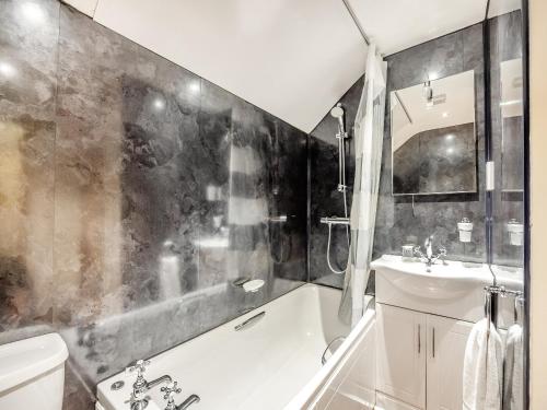 een badkamer met een bad en een wastafel bij The Hayloft - Uk44519 in Tetney