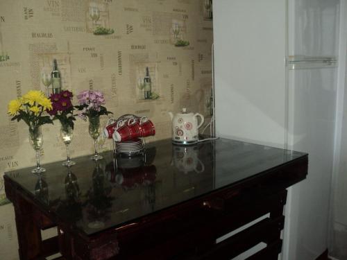 a table with vases and flowers on top of it at Apartment on Vasylia Stusa St, 10 in Bila Tserkva
