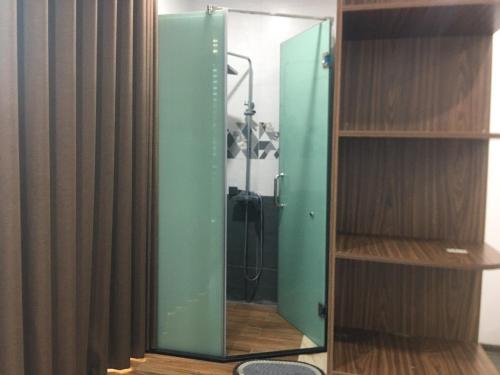 um espelho verde num quarto com um chuveiro em Paradise Home Ton Duc Thang em Hanói