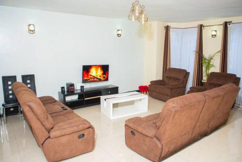 a living room with two chairs and a tv at Forget your worries in this serene 5 Bedroom Villa in Ngong in Nairobi