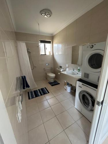 y baño con lavadora y lavadora. en Unit 4 3 Mouarn St Carey Park en Glen Iris