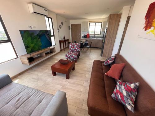 a living room with a couch and a flat screen tv at DEPARTAMENTO 5to piso CON VISTA AL MAR in Playas
