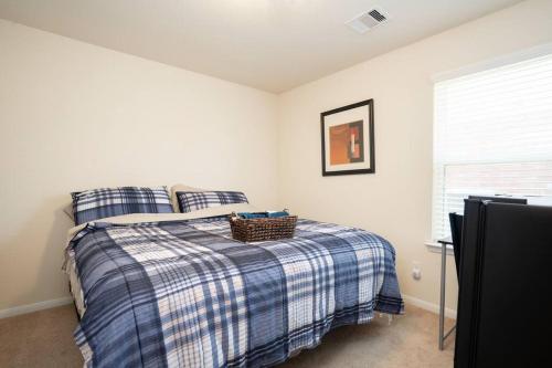 Un dormitorio con una cama con una manta a cuadros. en Select Exclusive Room in Fresno Texas, en Fresno