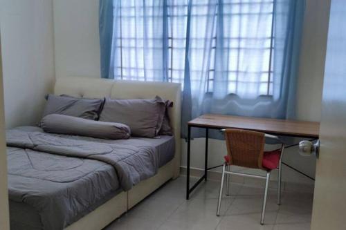 1 dormitorio con cama, mesa y escritorio en As-Salam Homestay, en Sungai Petani