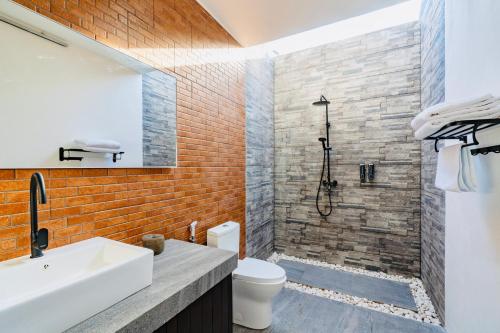 a bathroom with a shower and a sink and a toilet at Casa Canguro Villa in Nusa Lembongan
