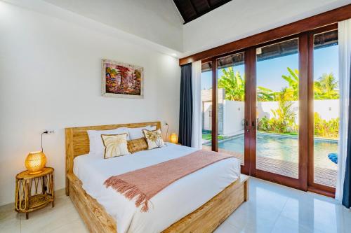 a bedroom with a bed with a view of a pool at Casa Canguro Villa in Nusa Lembongan
