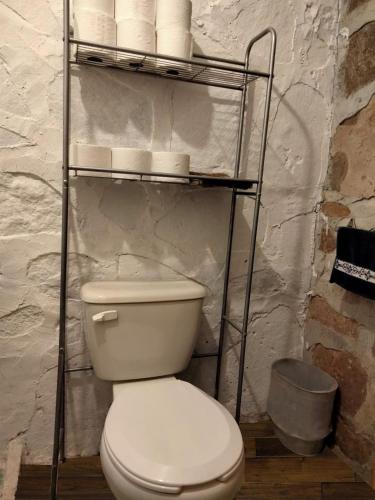 La salle de bains est pourvue de toilettes et d'une étagère avec du papier toilette. dans l'établissement Casita en el bosque, à Tepotzotlán