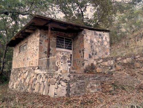 un antiguo edificio de piedra en una colina con ventana en Casita en el bosque, en Tepotzotlán