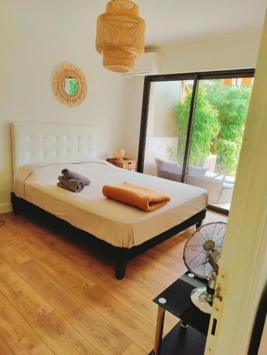 une chambre avec un lit et une grande fenêtre dans l'établissement Garden Flat in Cannes, à Cannes