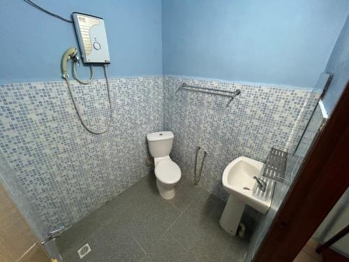 La salle de bains est pourvue d'une douche, de toilettes et d'un lavabo. dans l'établissement Dtahan Motel Taman Negara, à Kuala Tahan