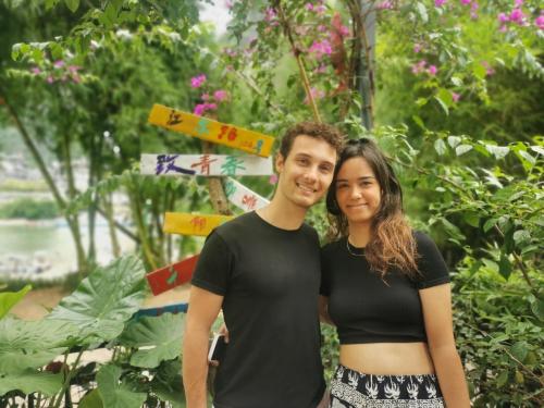 a man and a woman standing in front of a garden at Yangshuo Jing Yuan Inn Near The West Street in Yangshuo