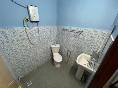 un bagno con doccia, WC e lavandino di Dtahan Motel Taman Negara a Kuala Tahan