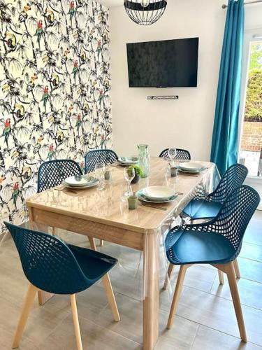 une table en bois avec des chaises et une salle à manger dans l'établissement Martin Appartement Cambrai avec cour, à Cambrai