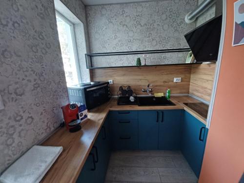 a small kitchen with a sink and a microwave at Apartament Provence in Burgas