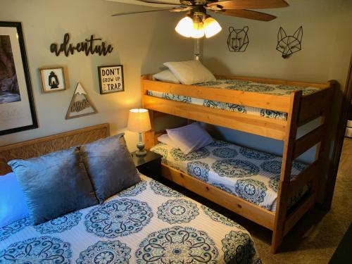 a bedroom with two bunk beds and a ceiling fan at Giant Steps 17 Ski In-out in Brian Head