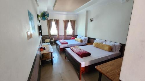 una camera con due letti e un divano in esso di Ngoc Son Hotel a Bien Hoa
