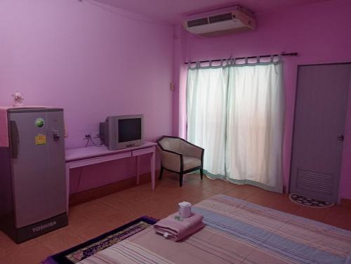 a room with a purple room with a tv and a desk at Anmol Hotel Thai Smile Group in Pattaya Central