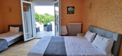 a bedroom with a large bed and a balcony at Hotel du Commerce Chez Stéphane in Roumazières