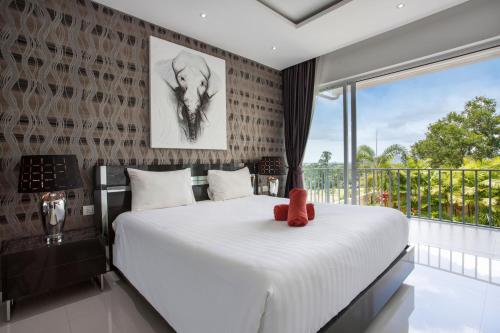 1 dormitorio con 1 cama grande y ventana grande en Three-Level Spacious Villa Dragon C, 4BR, Pool & Terrace, en Ban Klang