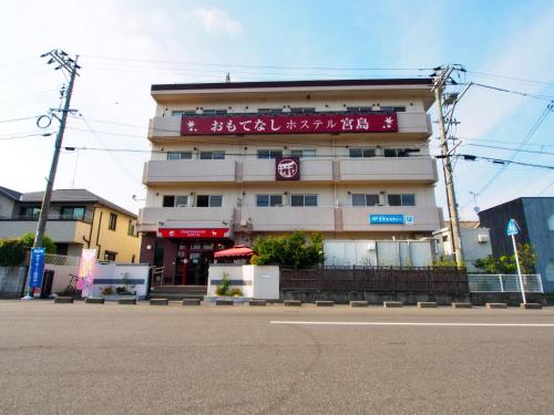 a building with a sign on the side of it at Omotenashi Hostel Miyajima in Hatsukaichi