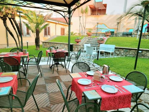 un grupo de mesas y sillas en un patio en Hotel Garibaldi, en Milazzo