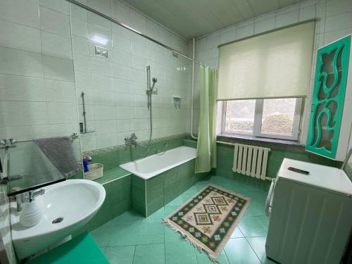 La salle de bains est pourvue d'un lavabo et d'une baignoire. dans l'établissement Guest House Botanika, à Bishkek