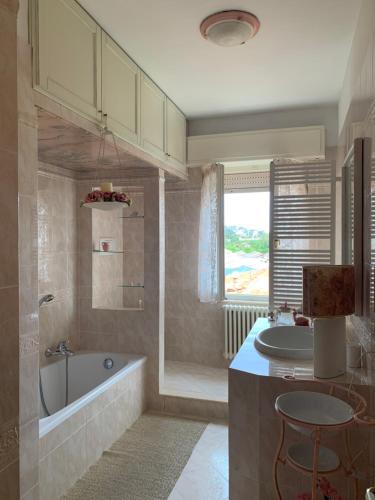 een badkamer met een bad, een wastafel en een bad bij Casa Viola vicino al mare by SMART-HOME in Vallecrosia