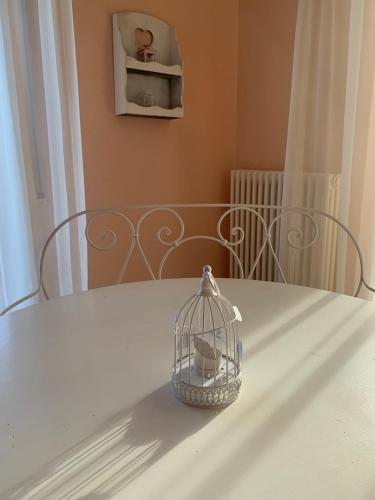 a bird cage sitting on top of a white table at Casa Viola vicino al mare by SMART-HOME in Vallecrosia