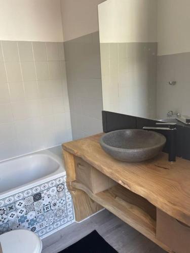 La salle de bains est pourvue d'un lavabo en pierre et d'une baignoire. dans l'établissement T2 au coeur de Luchon, à Luchon