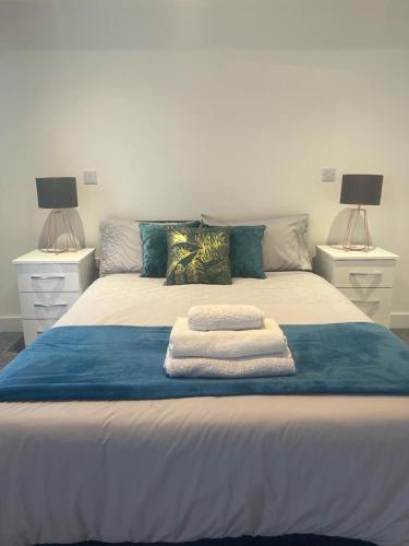 New modern 1 bedroom duplex apartment Hemel Hempstead High Street في هيميل هيمبستيد: غرفة نوم عليها سرير وفوط