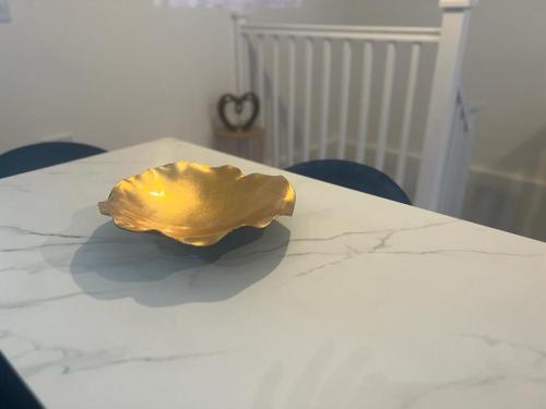 a gold object sitting on top of a white table at New modern 1 bedroom duplex apartment Hemel Hempstead High Street in Hemel Hempstead