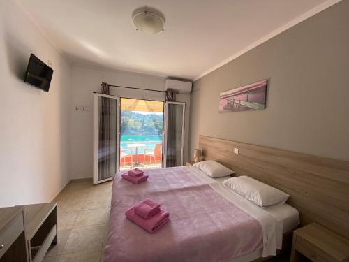 Un dormitorio con una cama grande con toallas rosas. en Miltos Studios, en Paleokastritsa