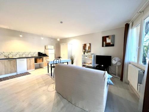 un salon avec une table et une cuisine dans l'établissement La Vigne et L'Olivier, à Villeneuve-lès-Avignon