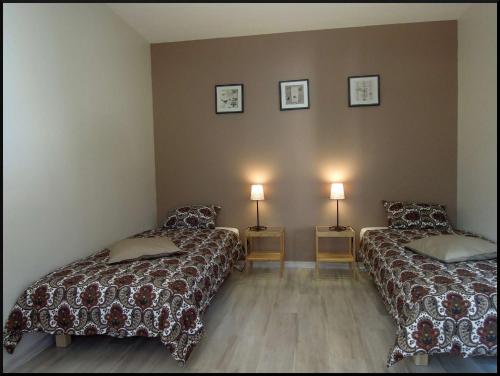 Cette chambre comprend 2 lits et 2 lampes murales. dans l'établissement La Vigne et L'Olivier, à Villeneuve-lès-Avignon