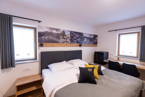 een slaapkamer met een groot bed en 2 ramen bij Turizem Loka - Hotel Vila Loka in Škofja Loka