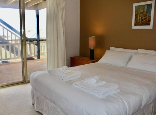 a bedroom with a white bed with towels on it at Ashani - My house is your house. in Augusta