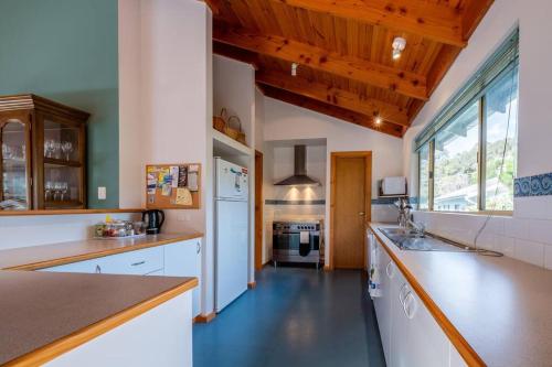 a large kitchen with white appliances and wooden ceilings at Ashani - My house is your house. in Augusta