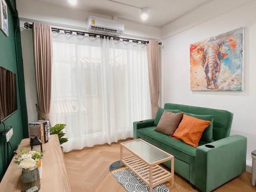 a living room with a green couch and a table at Entire floor,Decorated cozy home, near Grand Palace in Bangkok
