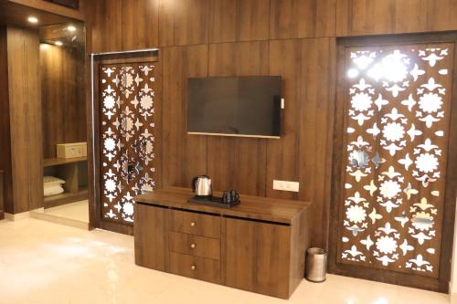 a room with a tv and a wooden wall at Stamps by Eight Continents, Jodhpur in Jodhpur