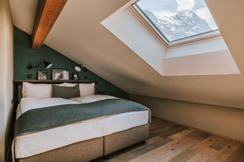 a bedroom with a bed with a skylight at Hotel Fiescherblick in Grindelwald