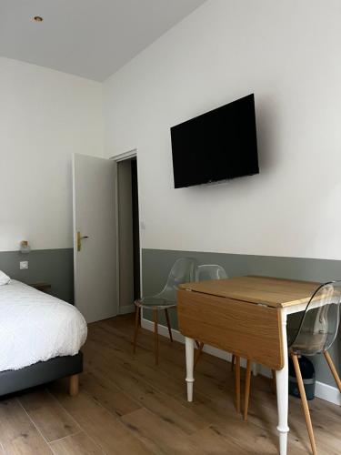 une chambre avec un lit, un bureau et une télévision dans l'établissement Le calme au coeur de ville, à Boulogne-sur-Mer