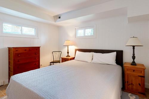 a bedroom with a bed and a dresser and two windows at Town of Dewey Beach --- 6 Jersey Street in Dewey Beach