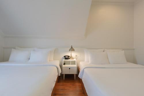 two beds sitting next to each other in a room at Le Soleil Boutique Hotel in Da Lat