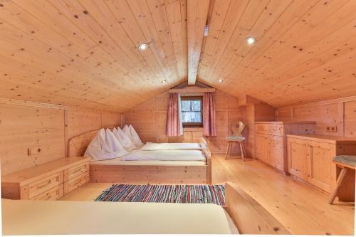a room with a bed in a wooden cabin at Jörgishof in Untertscheltsch